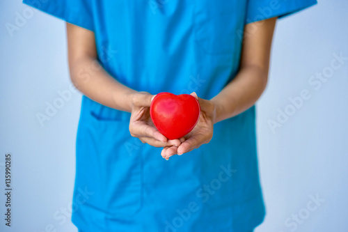 Closeup of young woman doctor hands with ball heart shape
