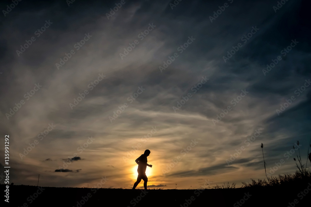 Silhouette running man in sunset time
