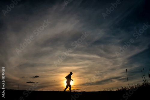 Silhouette running man in sunset time