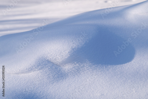 sunlight and shadows on snowdrifts in sunny day