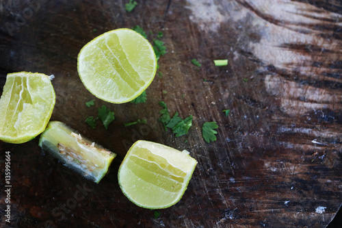 Cut into slices of lime on wooden background, empty space for your text, recipe