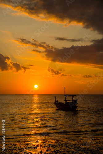 Long tailed boat at sunset