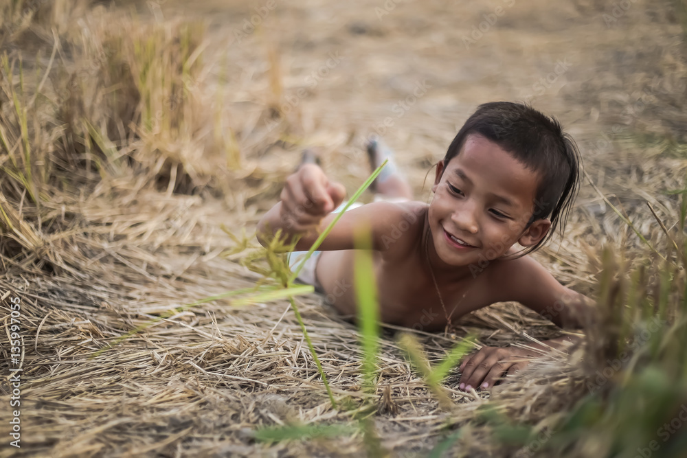 A boy thai ancient hairstyle play in farm,thailand A boy thai ancient hairstyle play in farm,thailand