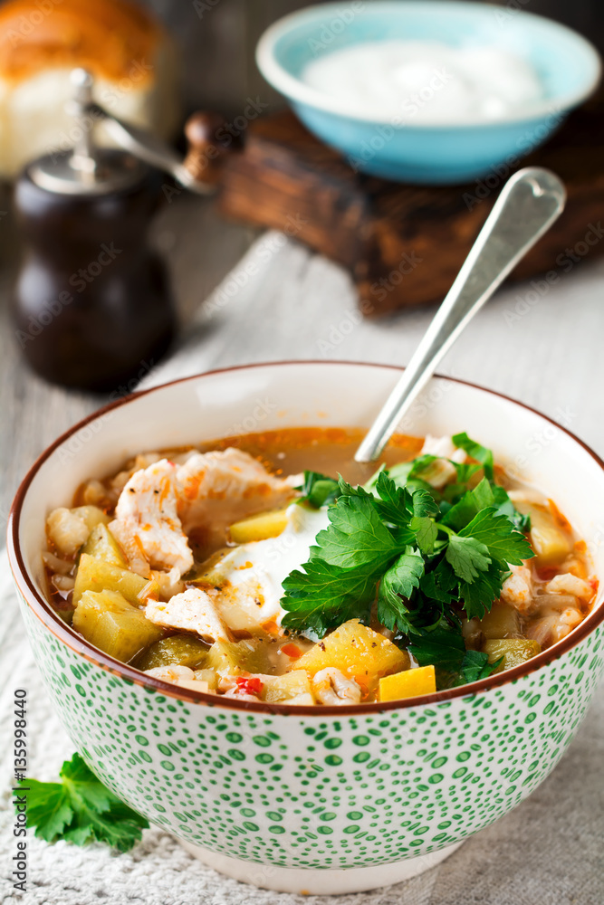 Traditional Russian soup-Rassolnik wit hpickled cucumber, barley, chicken, tomatoes and parsley in ceramic bowl. Selective focus. Traditional Russian soup-Rassolnik wit hpickled cucumber, barley, chicken, tomatoes and parsley in ceramic bowl. Selective focus.
