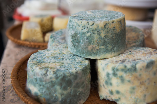 Old goat cheese with blue mold on farmer's market