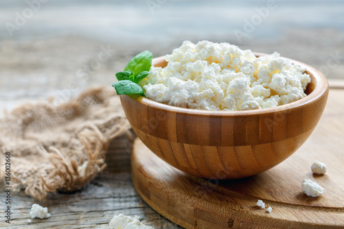 Fresh cottage cheese and mint in a wooden bowl.