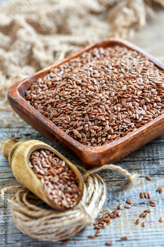 Foto Brown flax and wooden scoop in a square bowl.