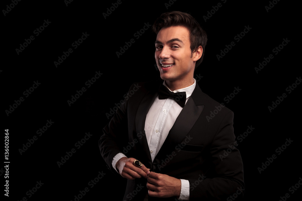 laughing young elegant man buttoning his tuxedo laughing young elegant man buttoning his tuxedo