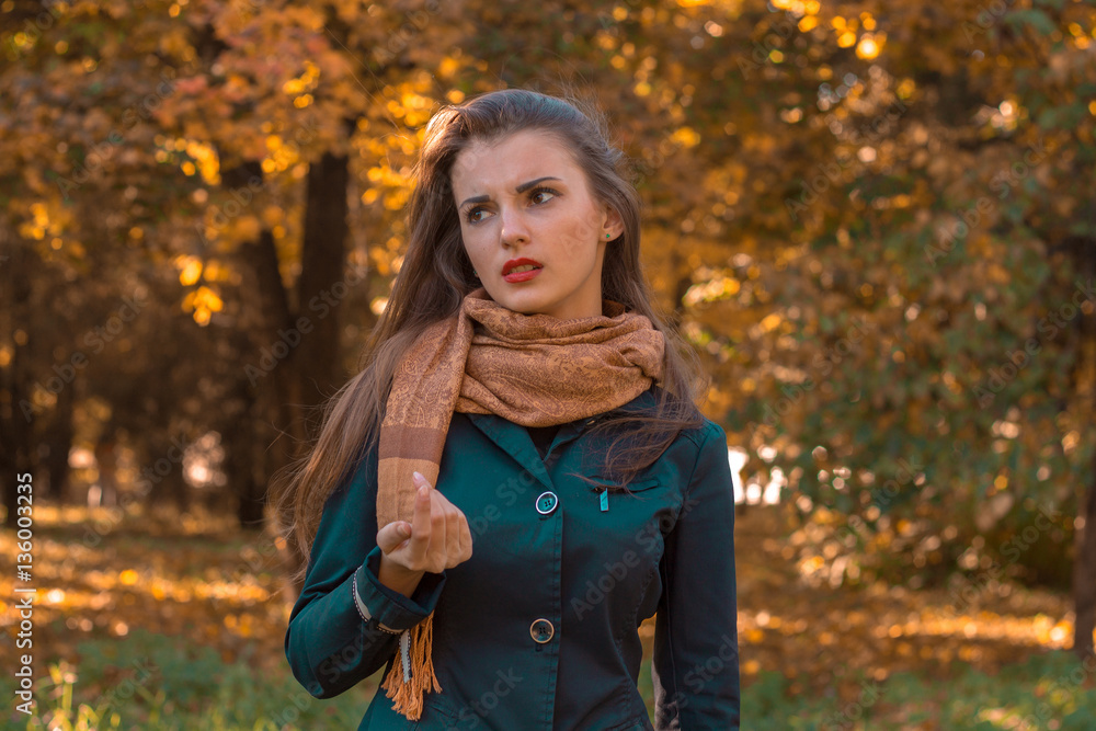 young girl in Brown silk scarf stands in the Park and looks away young girl in Brown silk scarf stands in the Park and looks away