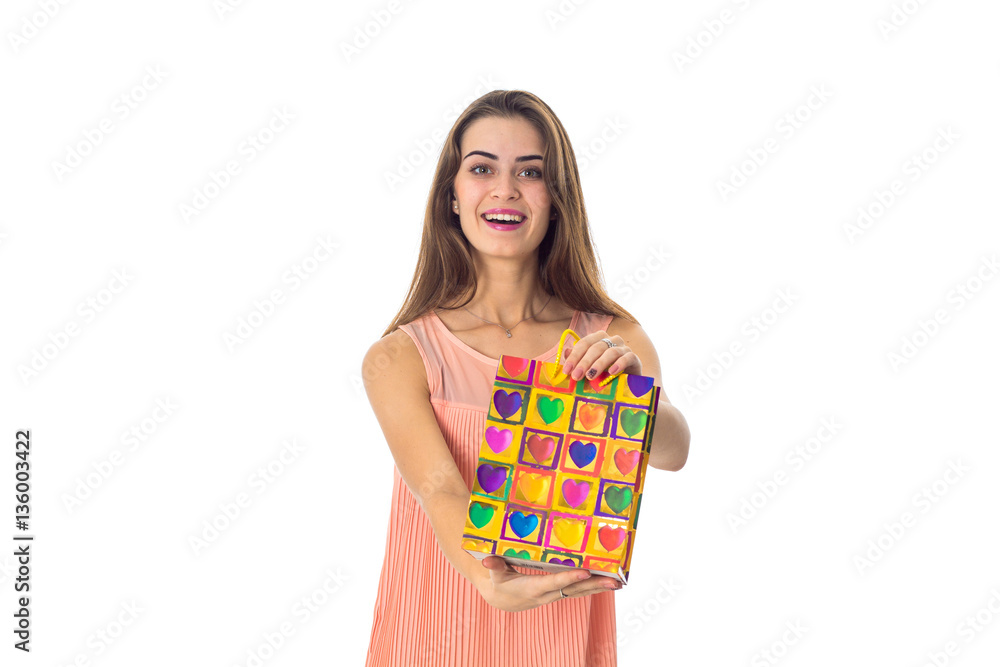 beautiful young girl in a bright dress holding package and smiling beautiful young girl in a bright dress holding package and smiling