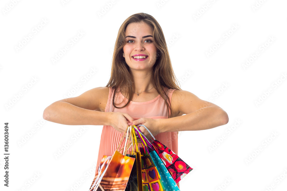 cheerful young girl keeps two hands different colored packages with purchases and smiling cheerful young girl keeps two hands different colored packages with purchases and smiling