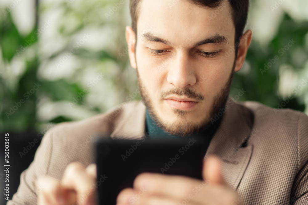 Closeup portrait of successful businessman using digital tablet in a cafe Closeup portrait of successful businessman using digital tablet in a cafe
