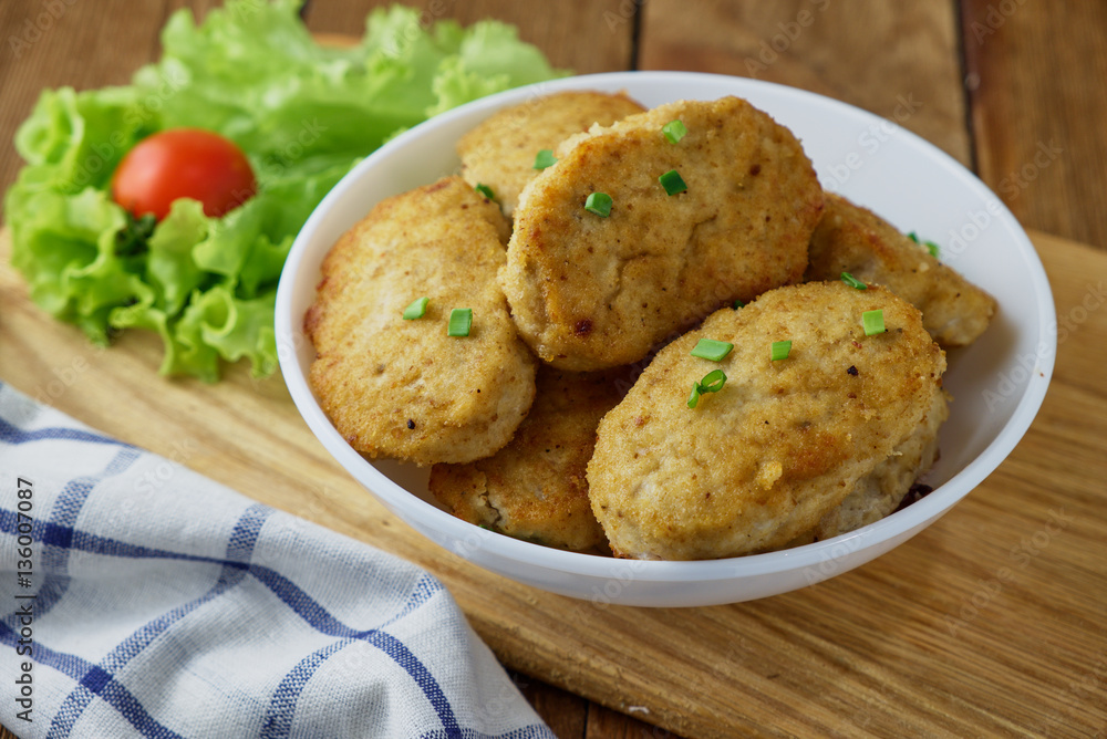 Chicken cutlets with vegetables on a wooden background Chicken cutlets with vegetables on a wooden background