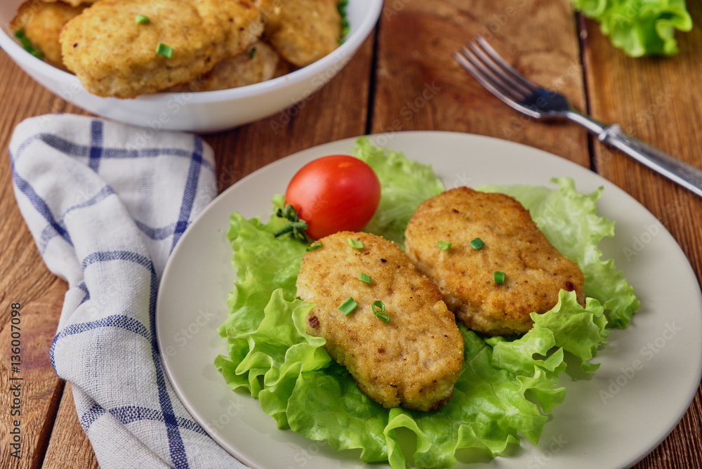 Chicken cutlets with vegetables on a wooden background Chicken cutlets with vegetables on a wooden background