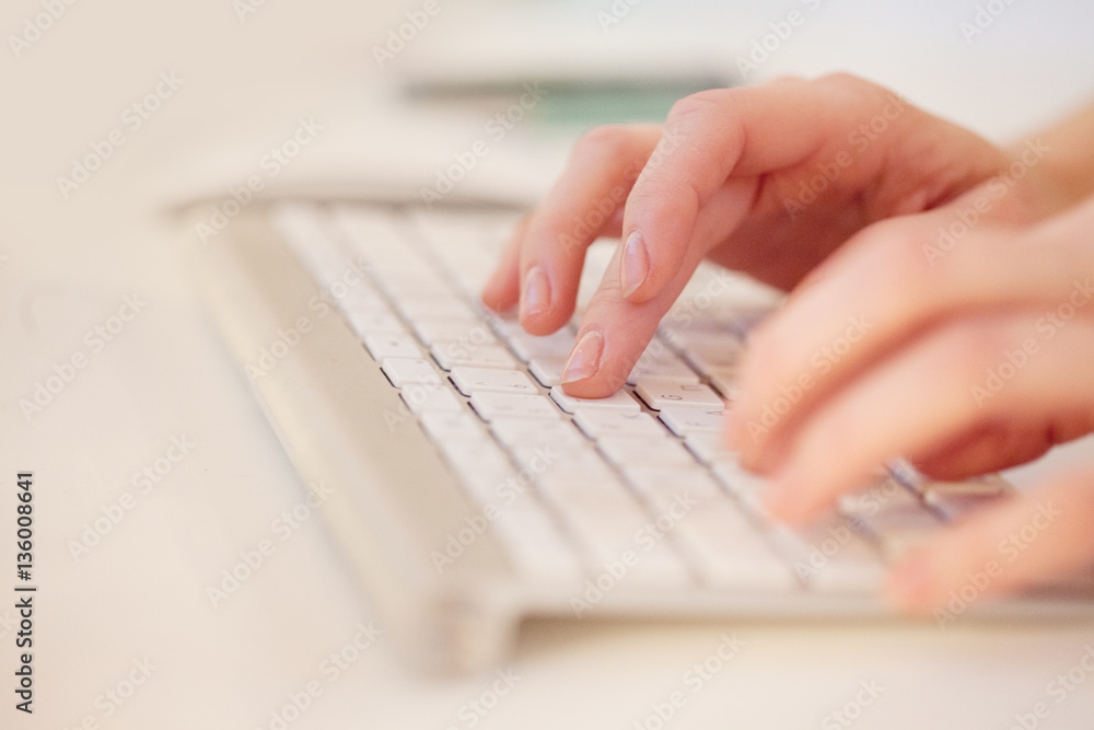 Closeup of a female hands typing on laptop keyboard in the office Closeup of a female hands typing on laptop keyboard in the office