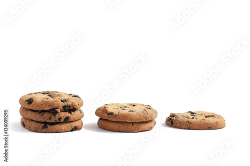 delicious cookies with chocolate piled into three stacks of three, two and one on a white background