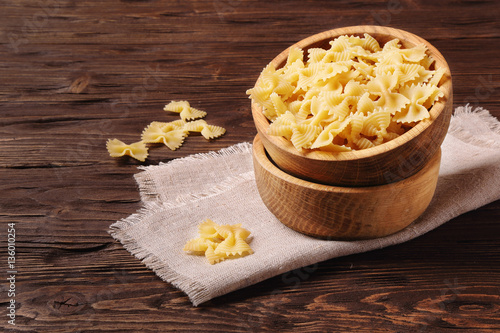 Pasta farfalle in a wooden bowl photo