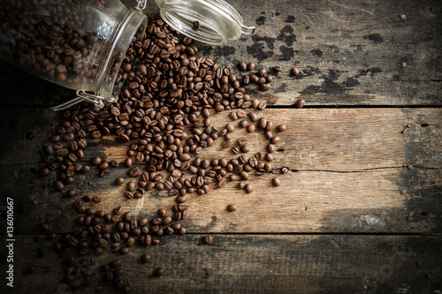 Coffee beans on the grunge wood background.