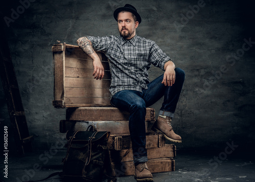 Stylish man sits on a wooden box.