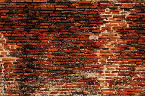 Damaged brick wall crossing over time from ancient up until now