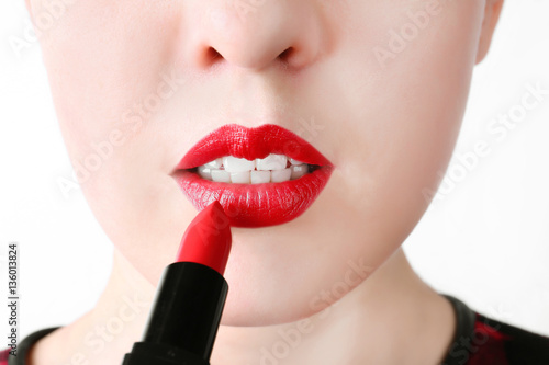 Woman applying lipstick, closeup