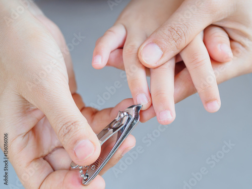 Family activity mother hand cut nails for kid by using nail clipper