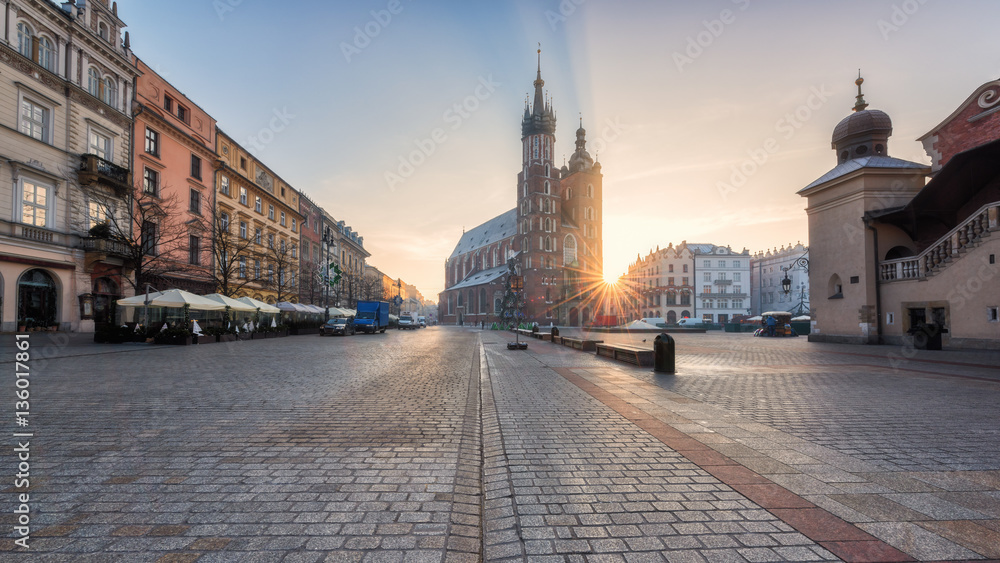 Panorama of Krakow architectural ensemble, sunrise over the old town Market square with St. Mary's church (Mariacki cathedral), Cloth Hall (Sukiennice) and colorful buildings, Poland, Europe
