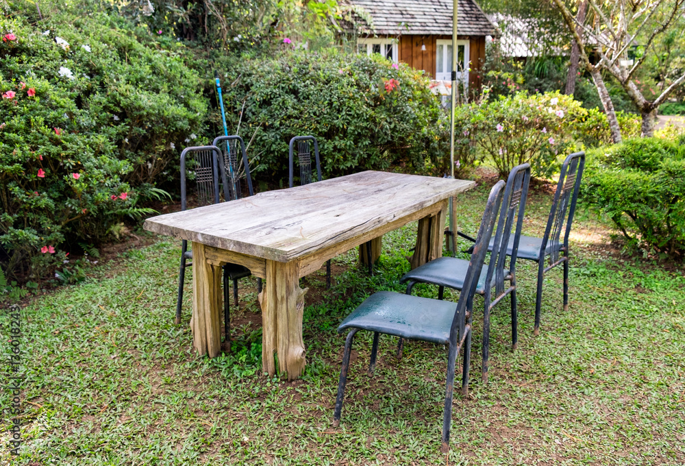 Wood table with chairs in shady garden