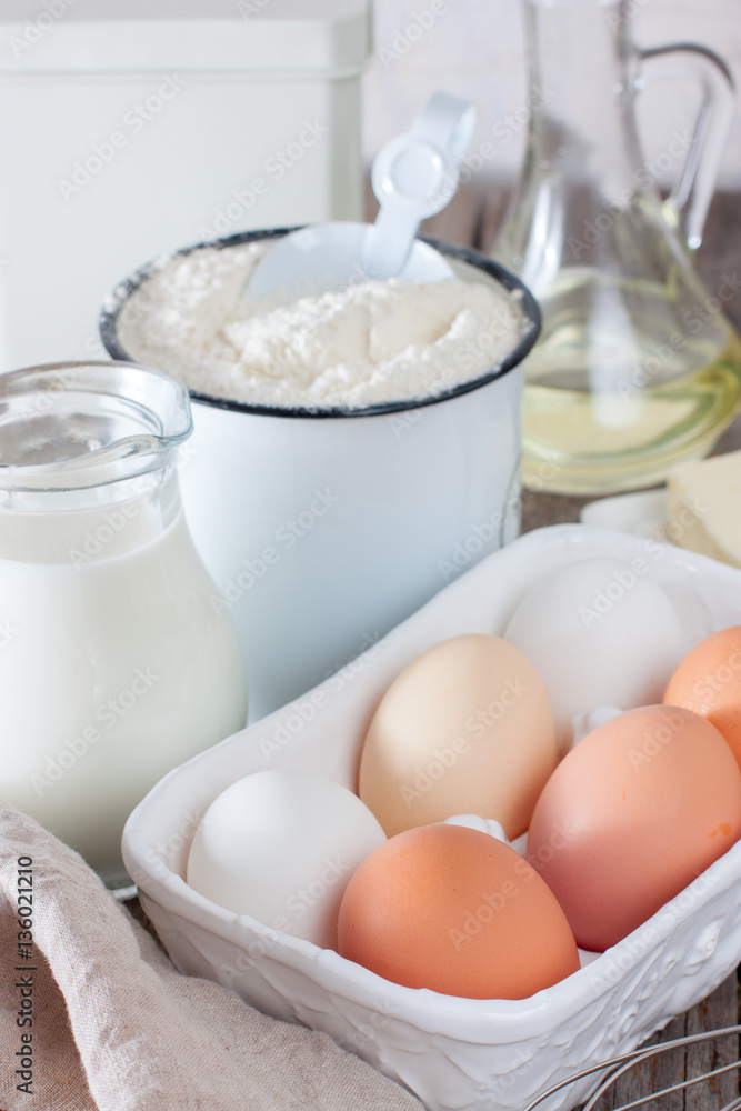 ingredients for making pancakes or cake - flour, egg, butter, milk on the old wooden background. ingredients for making pancakes or cake - flour, egg, butter, milk on the old wooden background.
