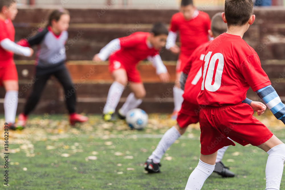  Boys kicking soccer ball at sports field