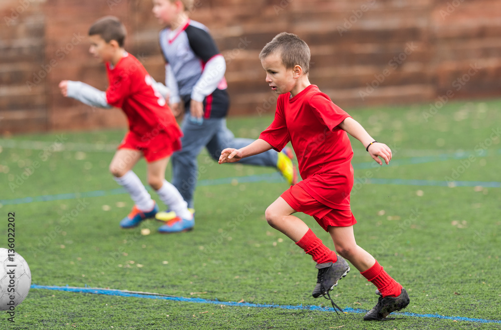 Obraz premium Boy kicking soccer ball