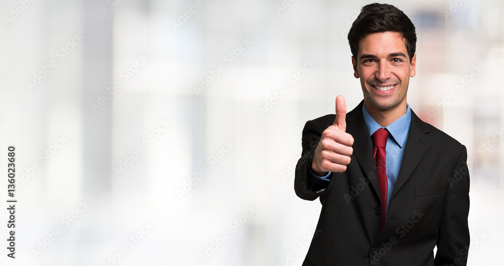 Businessman giving thumbs up. Large bright blurred copy-space Businessman giving thumbs up. Large bright blurred copy-space