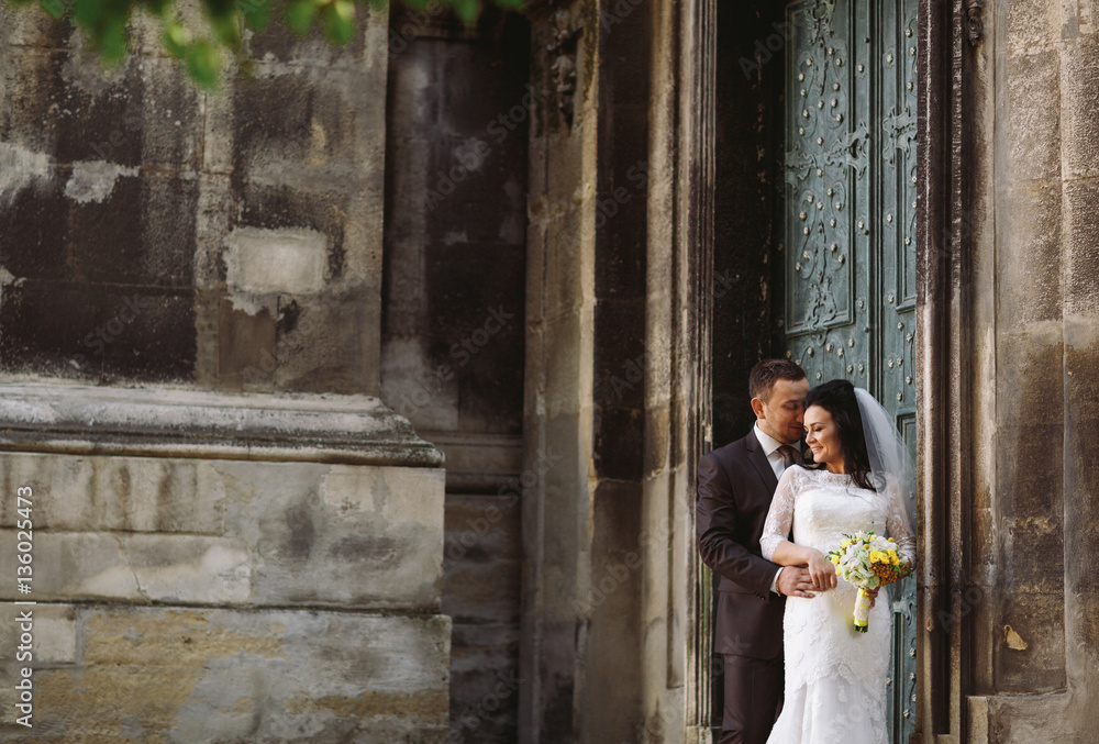 Adorable newlyweds next to the old building