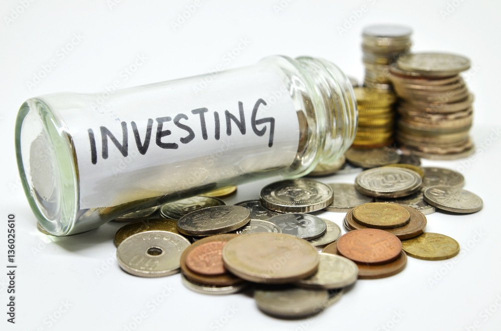 Investment lable in a glass jar with coins spilling out Investment lable in a glass jar with coins spilling out