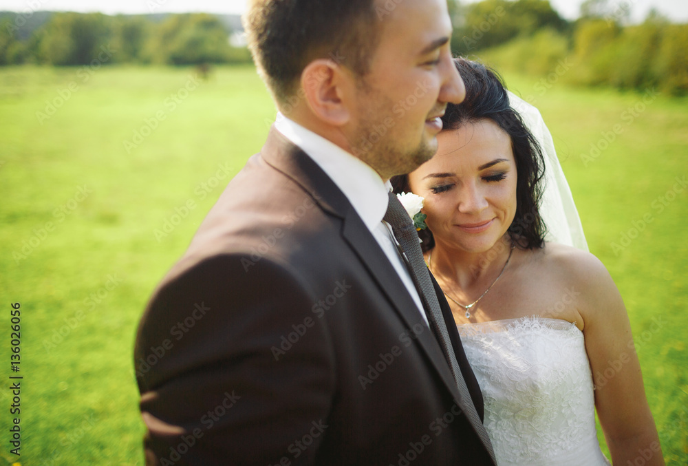 Bright photo of the newlyweds on the green meadow Bright photo of the newlyweds on the green meadow