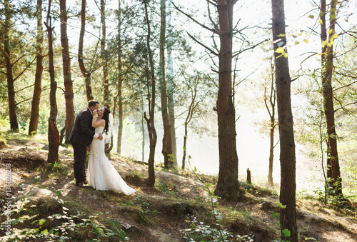 Romantic kiss of the newlyweds with the smoke in the wood