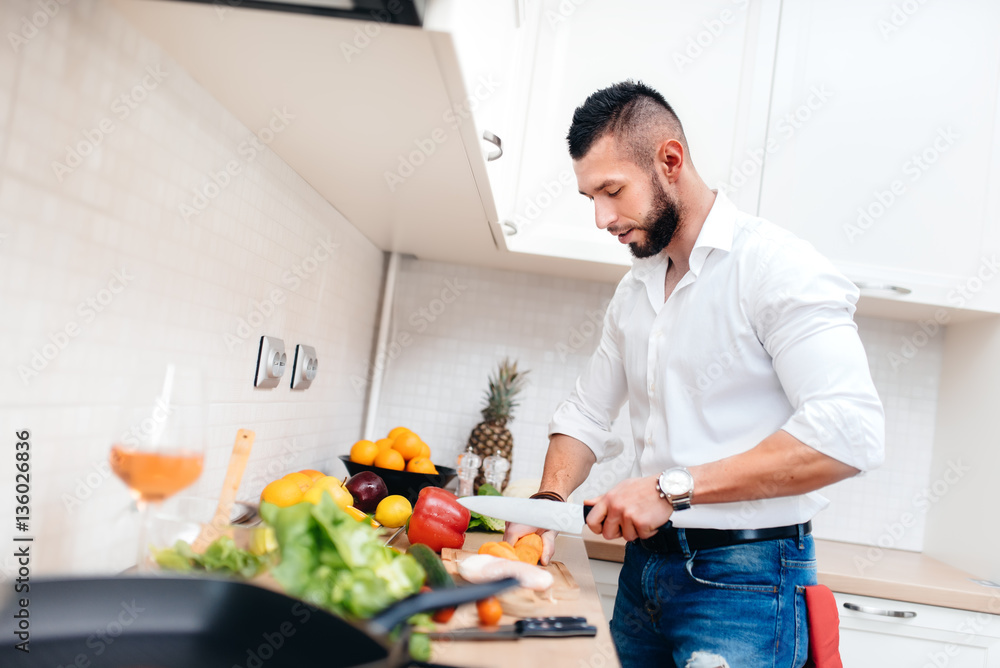 Classy man with elegant shirt cooking dinner for girlfriend. Close up of kitchen cook cutting vegetables and preparing salad Classy man with elegant shirt cooking dinner for girlfriend. Close up of kitchen cook cutting vegetables and preparing salad