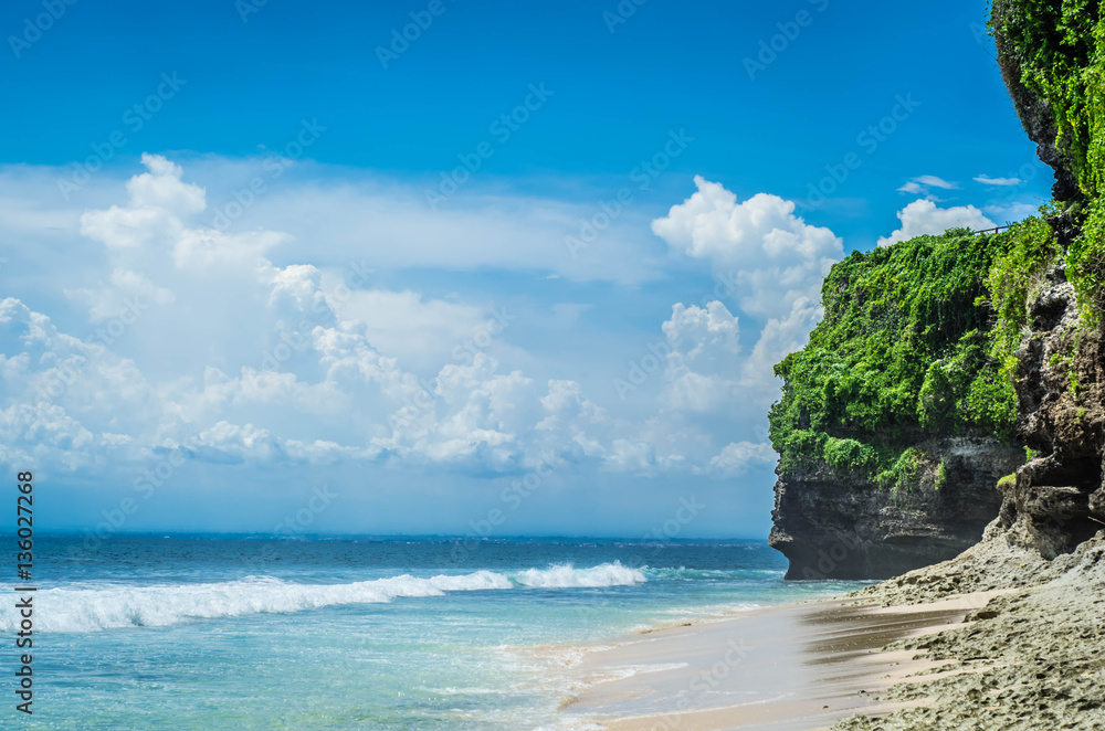 Am incredibly beautiful view of an ocean tropical beach with blue sky, white clouds and cliffs, Indonesia