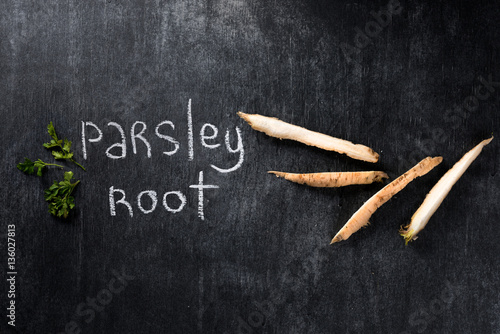 Image of parsley root over dark chalkboard background.