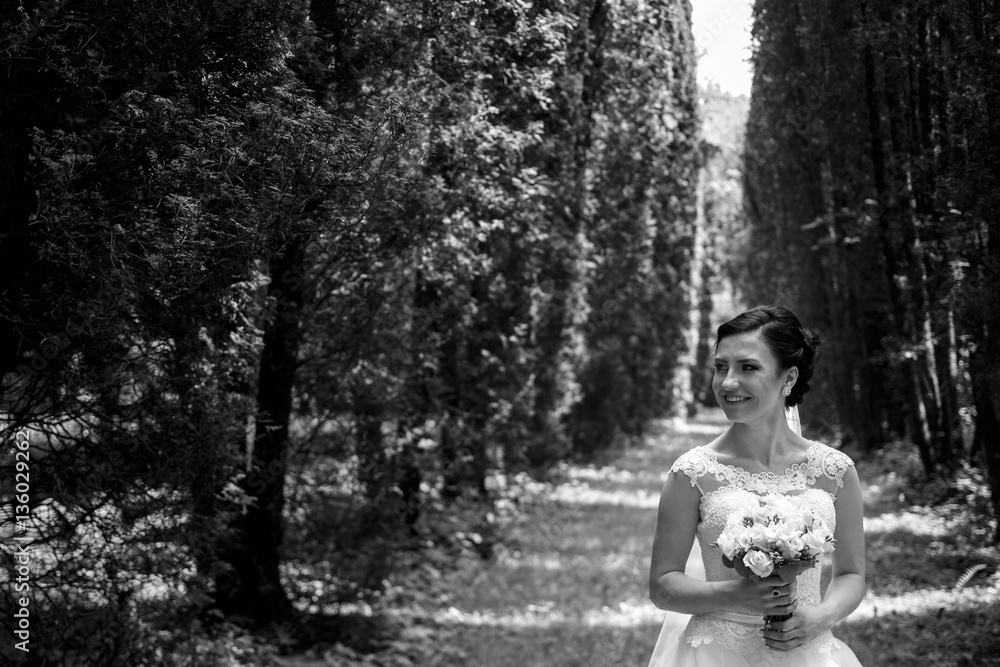 Bride smiles while she stands in dense forest