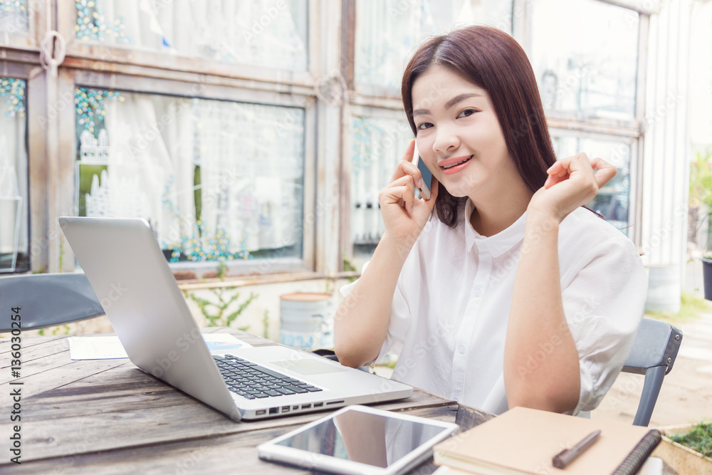 young happy casual asian woman using technology on her laptop co young happy casual asian woman using technology on her laptop co
