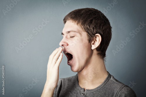 Portrait of tired teen who yawns