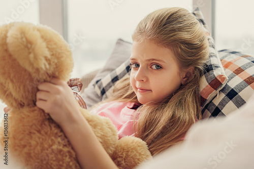 Innocent girl playing with toy bear