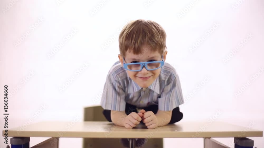 Funny smiling boy with glasses sitting astride school desk, four-year boy
Funny smiling boy with glasses sitting astride school desk, four-year boy