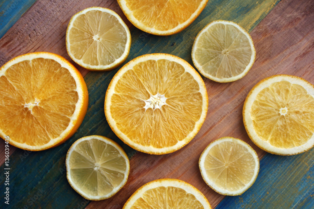 slices of lemon and orange on a wooden table slices of lemon and orange on a wooden table