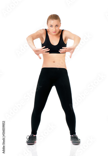 Photos Beautiful fitness woman posing in studio - showing how to keep fit doing warming up exercises