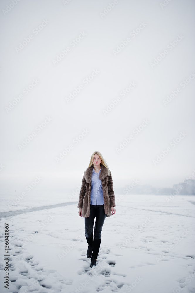 Portrait of young elegance blonde girl in a fur coat background Portrait of young elegance blonde girl in a fur coat background