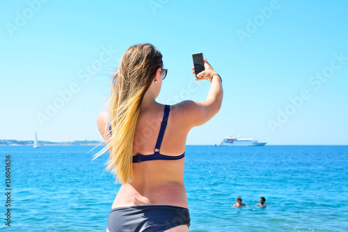 Beautiful girl with a mobile phone on the beach.