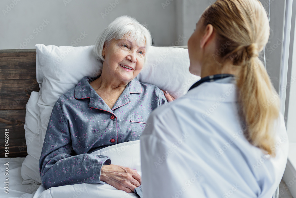 Fototapeta premium Therapeutic taking care of her client in hospital room