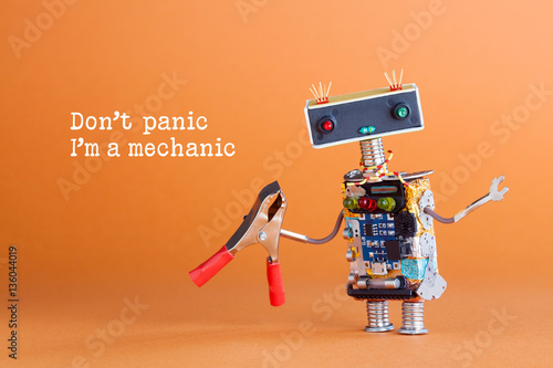 Don't panic I'm a mechanic concept. Toy robot handyman with pliers ready for service work. Fun character colorful head red blue light bulbs eyes. Repairing concept, orange background photo